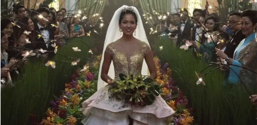 The bride in the movie smiling and holding a bouquet