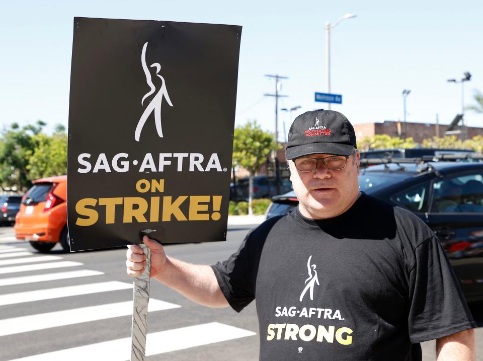 Sean Astin holds a sign while joining members of the Writers Guild of America and the Screen Actors Guild on a picket line outside of Paramount Studios in Los Angeles, California, on July 14, 2023.