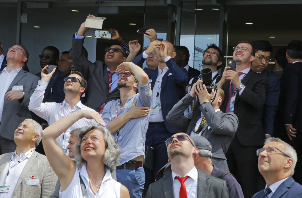 Visitors watch a demonstration flight at Paris Air Show, in Le Bourget, east of Paris, France, Tuesday, June 18, 2019. The world's aviation elite are gathering at the Paris Air Show with safety concerns on many minds after two crashes of the popular Boeing 737 Max. (AP Photo/Michel Euler)