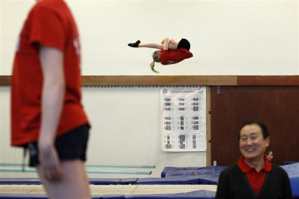 Crystal Palace diving club member Lexie Howard (C) practices during a training session in a dry diving gym in London March 9, 2012.