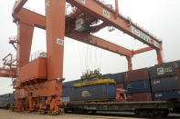 In this July 25, 2019, photo, a crane lifts a shipping container from a truck next to a cargo train bound for Europe at a train station in Dalian in northeastern China's Liaoning Province. Authorities in China's rust-belt region are looking for support for its revival from Beijing's multibillion-dollar initiative to build ports, railways and other projects abroad. (AP Photo/Olivia Zhang)