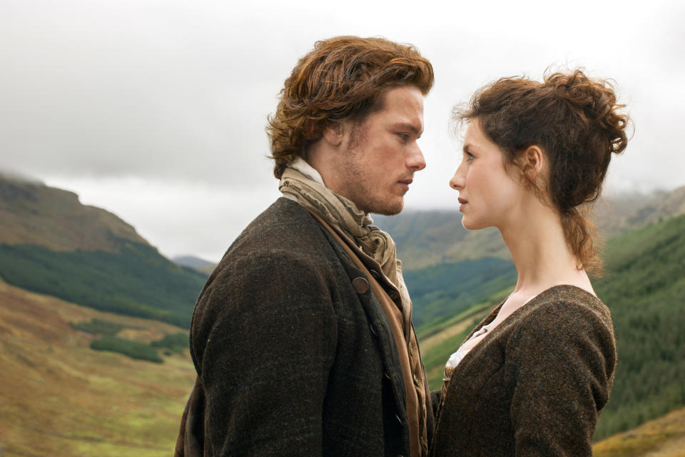 A man and a woman stare longingly at each other in the Irish highlands.