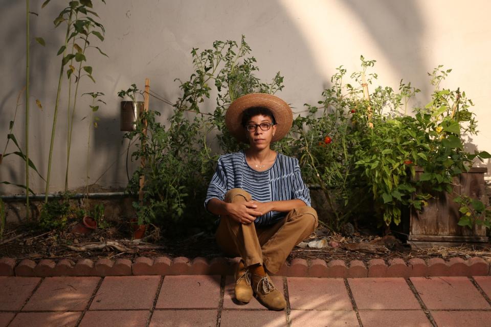 Jamie Williams sits with the garden she grew outside of her apartment.