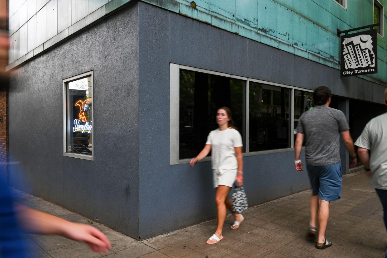People walk past City Tavern in downtown Greenville on Friday, May 3, 2024.