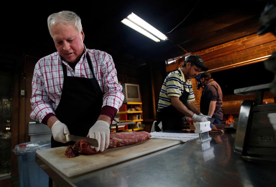 Jim Dial, left, cuts filets for the night as Ronnie Hill, second from left, marinates steaks as they go to the grill at Diamond Jim's and Mrs. Donna's restaurant in Livingston on Feb. 7, 2014.