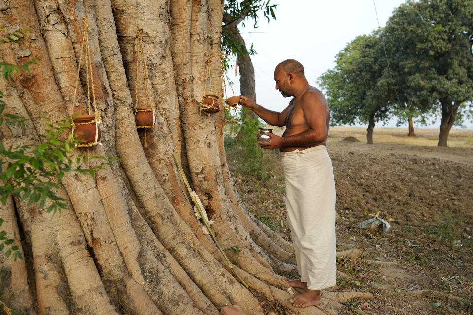 Vinod Kumar Singh, performs post cremation ritual for his father who passed away following heat related ailments in village Kothi, Ballia district, Uttar Pradesh state, India, Monday, June 19, 2023. Several people have died in two of India's most populous states in recent days amid a searing heat wave, as hospitals find themselves overwhelmed with patients. More than hundred people in the Uttar Pradesh, and dozens in neighboring Bihar state have died due to heat-related illness. (AP Photo/Rajesh Kumar Singh)