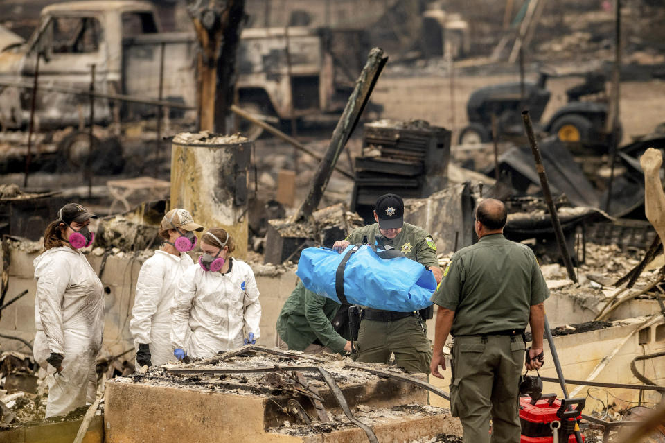 Sheriff's Deputy Johnson carries remains of a McKinney Fire victim from a destroyed home on Monday, Aug. 1, 2022, in Klamath National Forest, Calif. (AP Photo/Noah Berger)