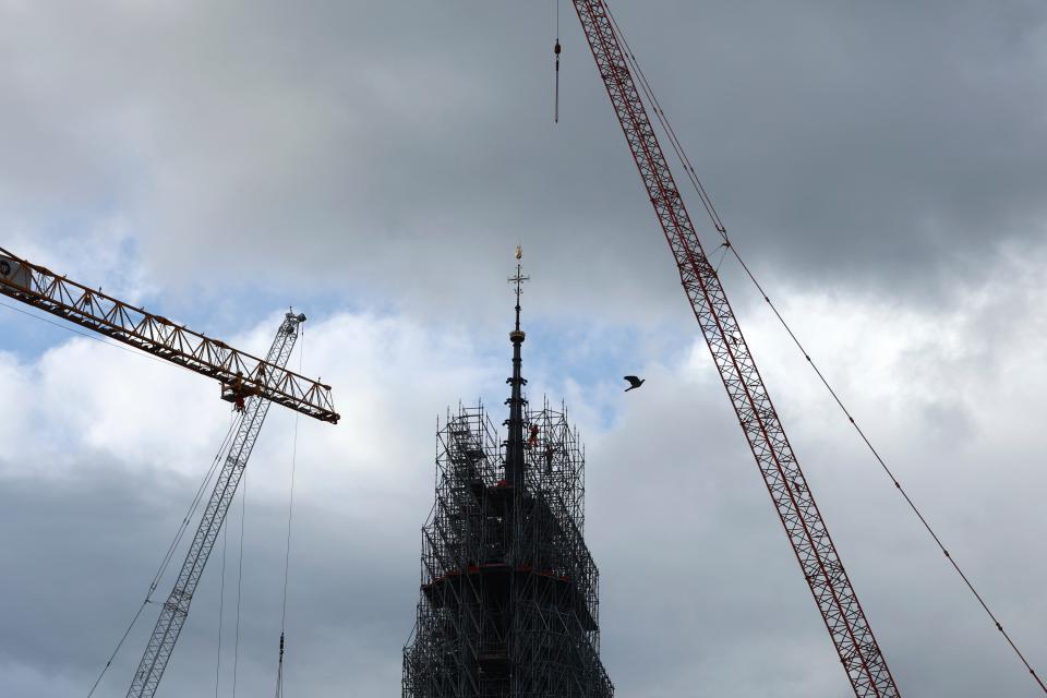 Scaffolding is being removed around the spire of Notre Dame de Paris cathedral, showing the rooster and the cross  on Monday in Paris. Notre Dame is expected to reopen in December following the devastating fire in April 2019.