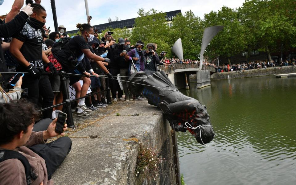 Protesters throw statue of Edward Colston into Bristol harbour during a Black Lives Matter protest rally - PA