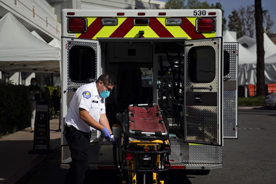 An EMT disinfects a gurney after transporting a patient at St. Joseph Hospital in Orange, Calif., Thursday, Jan. 7, 2021. California health authorities reported Thursday a record two-day total of 1,042 coronavirus deaths as many hospitals strain under unprecedented caseloads (AP Photo/Jae C. Hong)