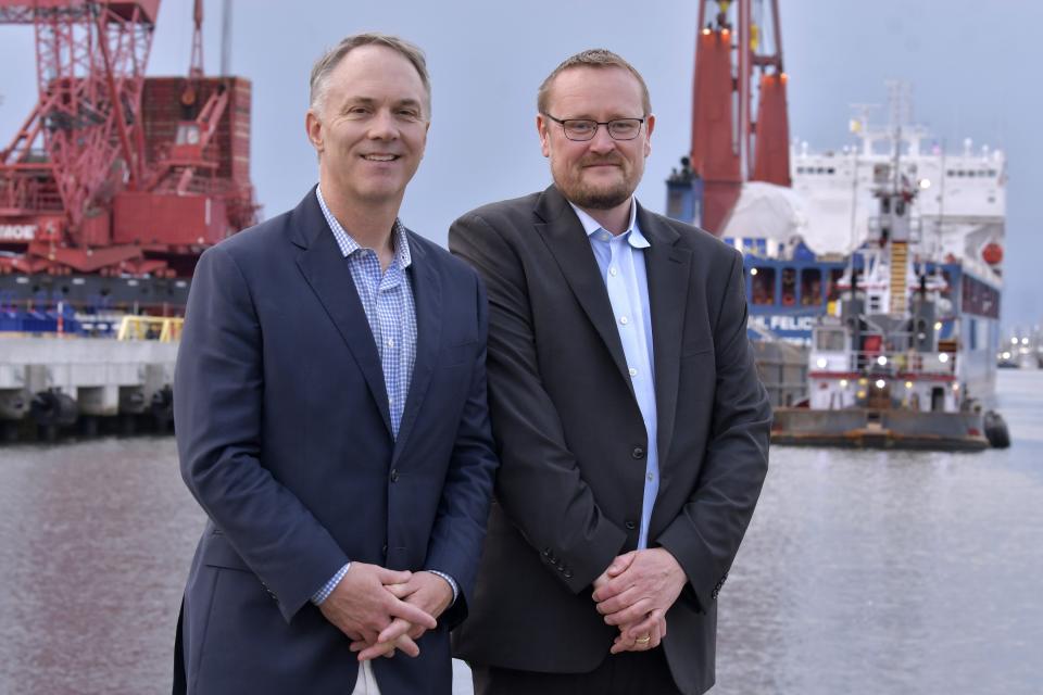 New Bedford Mayor Jon Mitchell, left, and Vineyard Wind CEO Klaus Skoust Moeller pose for a photo in front of the ship UHL Felicity, which docked in New Bedford Harbor, Wednesday, May 24, 2023, in Bedford, Mass. The vessel carried massive parts for offshore wind turbines. (AP Photo/Josh Reynolds)