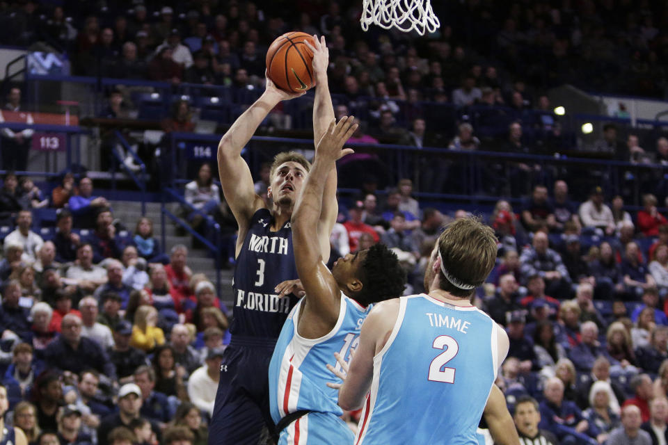 North Florida forward Carter Hendricksen, left, shoots while defended by Gonzaga guard Malachi Smith, center, during the first half of an NCAA college basketball game, Monday, Nov. 7, 2022, in Spokane, Wash. (AP Photo/Young Kwak)