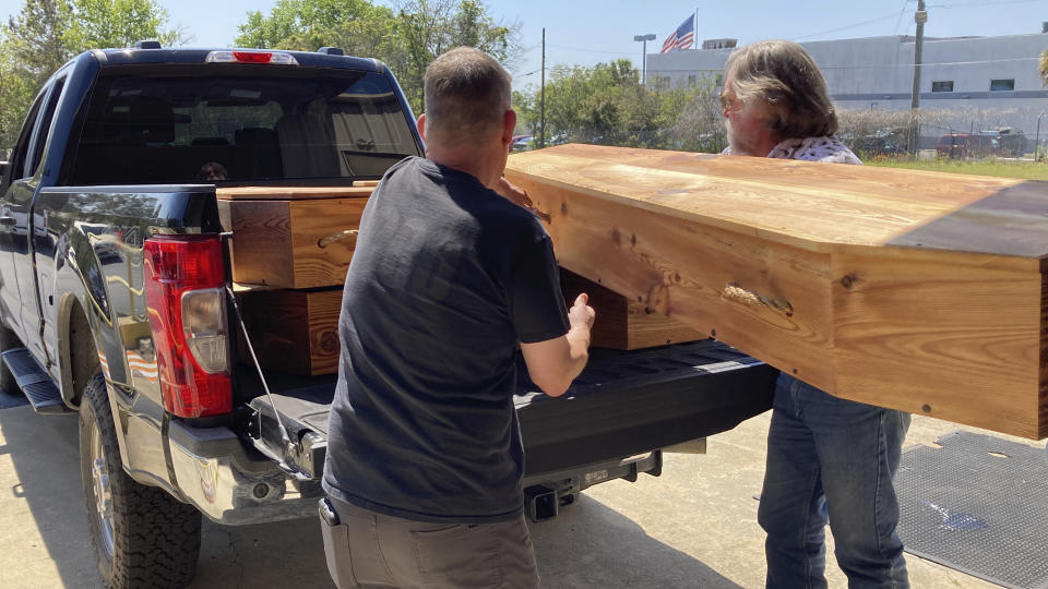 Forensic anthropologist Bill Stevens, left, and archeologist James Legg, right, remove homemade coffins to prepare the reburial of the remains of unidentified Revolutionary War soldiers killed in the Battle of Camden in 1780 for reburial on Thursday, March 30, 2023, in Columbia, South Carolina. The remains of 14 soldiers were removed from the battlefield, studied and analyzed and will be buried in a ceremony. (AP Photo/Jeffrey Collins)