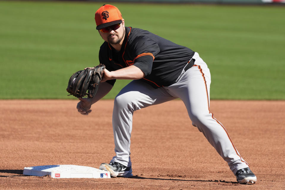 San Francisco Giants third baseman J.D. Davis takes a throw at third base during spring training baseball workouts, Monday, Feb. 19, 2024, in Scottsdale, Ariz. (AP Photo/Ross D. Franklin)