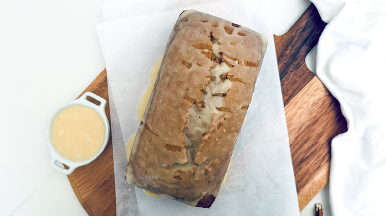 glazed applesauce cake loaf on wood board