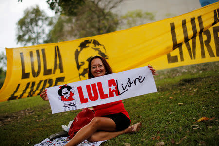 FILE PHOTO: A supporter of Brazil's former president Luiz Inacio Lula da Silva holds a sign reading "Free Lula" outside the Brazil's Superior Court Justice build during a session to try Lula's appeal in the court in Brasilia, Brazil April 23, 2019. REUTERS/Adriano Machado/File Photo