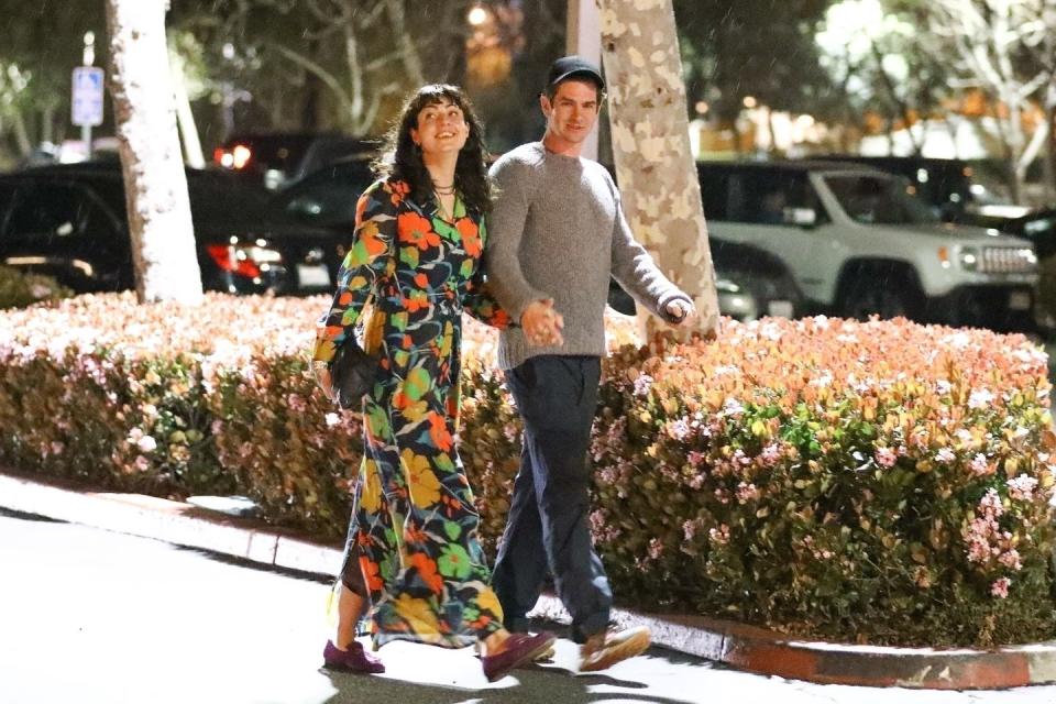 a man and woman walking down a sidewalk