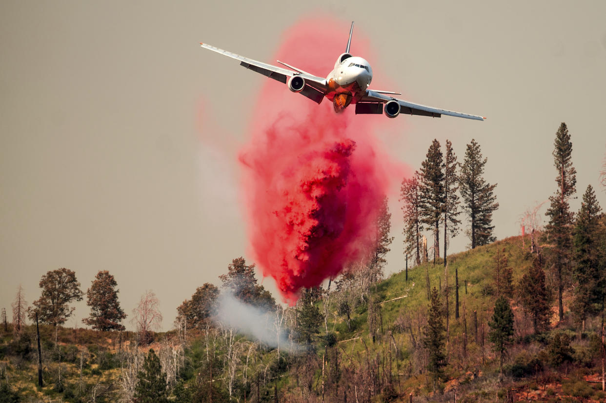 An air tanker drops retardant while trying to stop the Oak Fire from reaching the Lushmeadows community in Mariposa County, Calif., on Sunday, July 24, 2022. (AP Photo/Noah Berger)