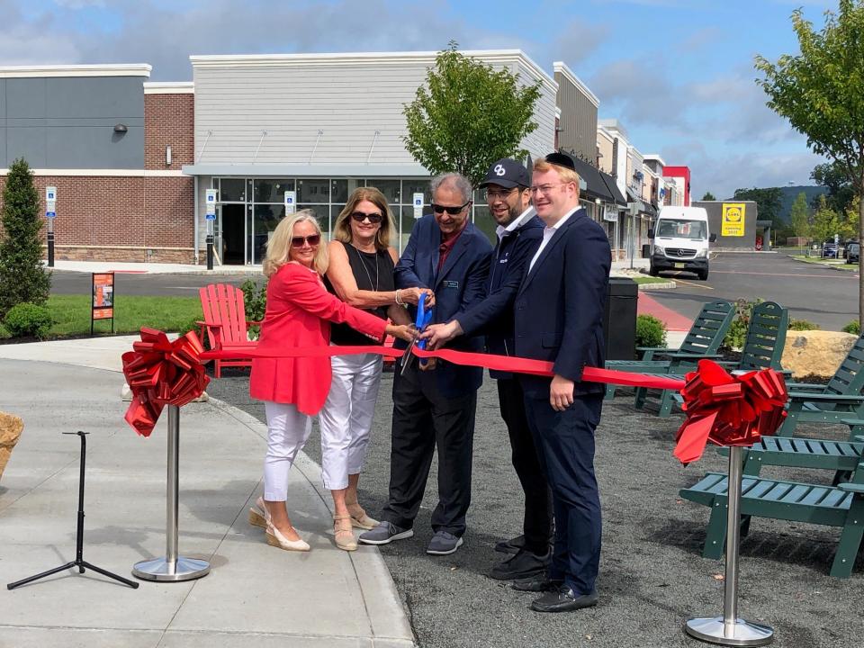 Morris Township Deputy Mayor Bud Ravitz, center, cuts the ribbon along with developers and architects of the Morris Marketplace to signify the official opening of the shopping center on East Hanover Avenue Tuesday, Aug. 8, 2023.