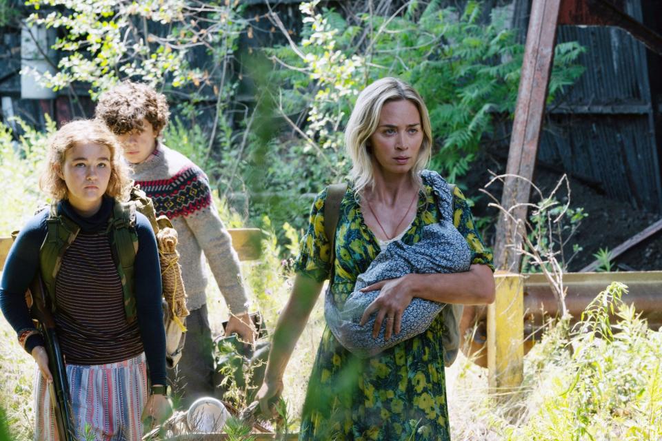 Emily Blunt carries a baby and leads Millicent Simmonds and Noah Jupe through some weeds