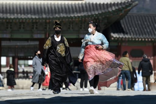 Visitors wearing traditional Korean hanbok dresses also donned face masks at Gyeongbokgung palace in Seoul as fears for the coronavirus mounted