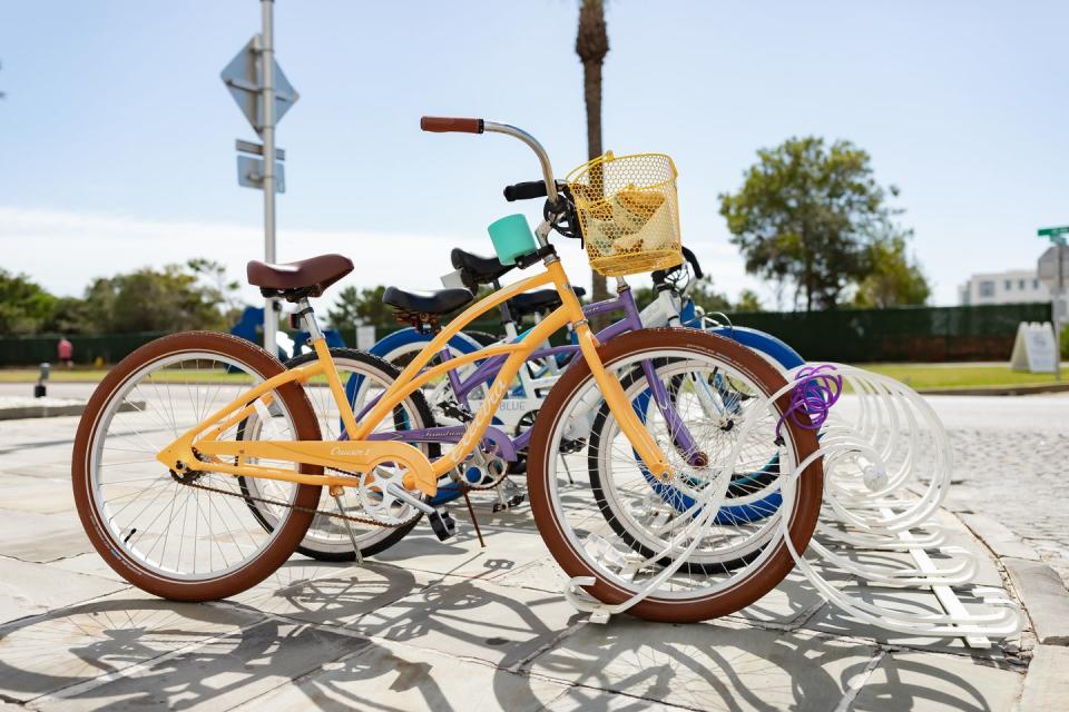 colorful bicycles parked at a bike stand in alys beach on a beautiful fall day with blue sky and sunshine