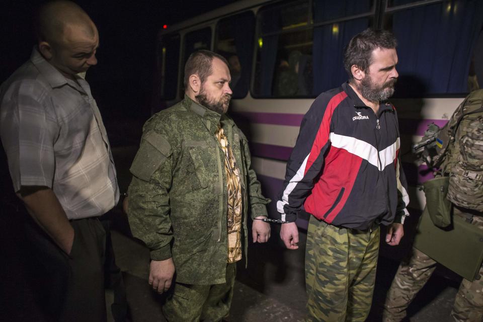 Members of the pro-Russian rebels, who are prisoners-of-war, stand by the side of a road as they wait to be exchanged, north of Donetsk, eastern Ukraine