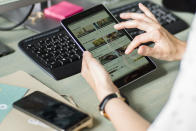 In this Tuesday, May 21, 2019 photo, Franziska Lienert spokeswoman of the company which runs the food sharing app 'Too Good To Go', uses a tablet to find a restaurant participating with the food sharing community, during an interview with the Associated Press in Berlin. In Germany, growing numbers of people use modern technology such as phone apps to help reduce food waste. In an effort to cut down on climate-wrecking carbon dioxide emissions created by food waste, they build online communities to share food before throwing it away. (AP Photo/Markus Schreiber)