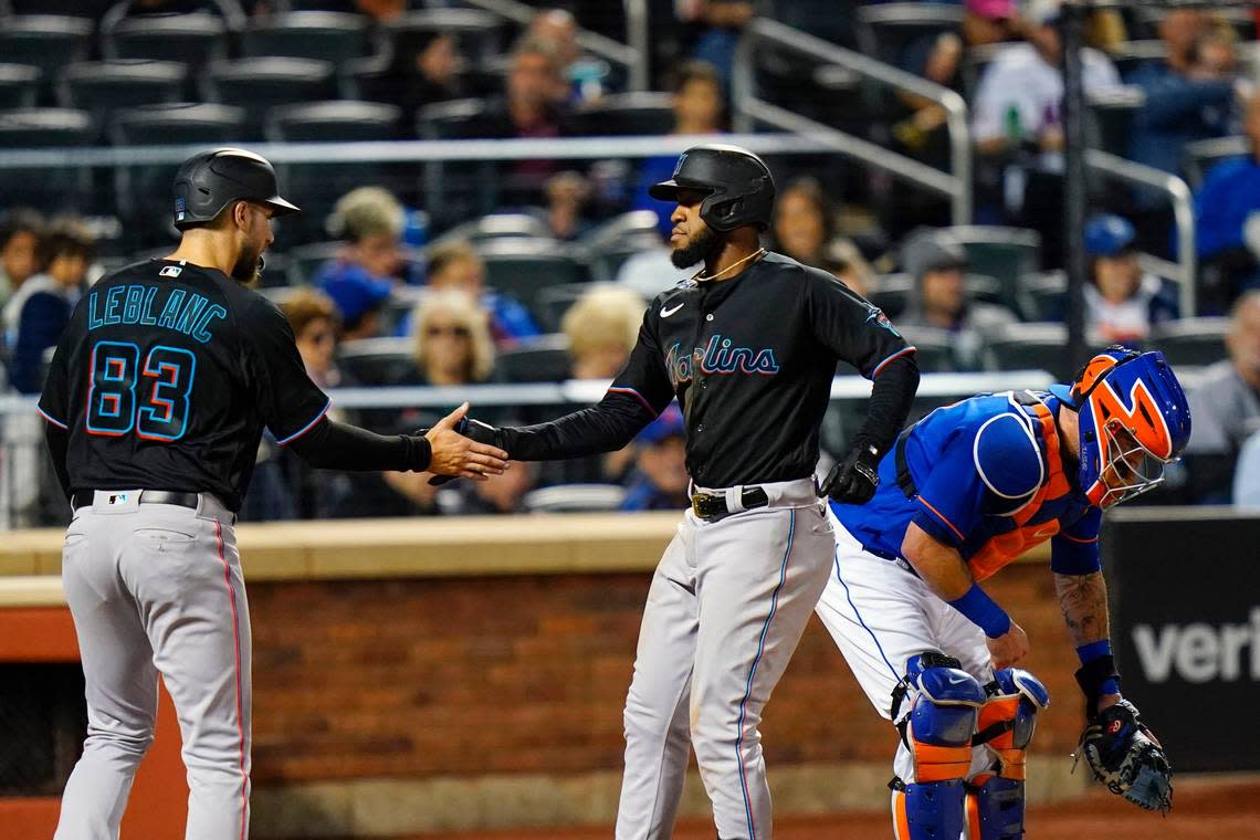 Miami Marlins’ Bryan De La Cruz, center, celebrates with Charles Leblanc, left, after hitting a two-run home run as he passes New York Mets catcher Tomas Nido during the fourth inning of a baseball game Wednesday, Sept. 28, 2022, in New York. (AP Photo/Frank Franklin II)