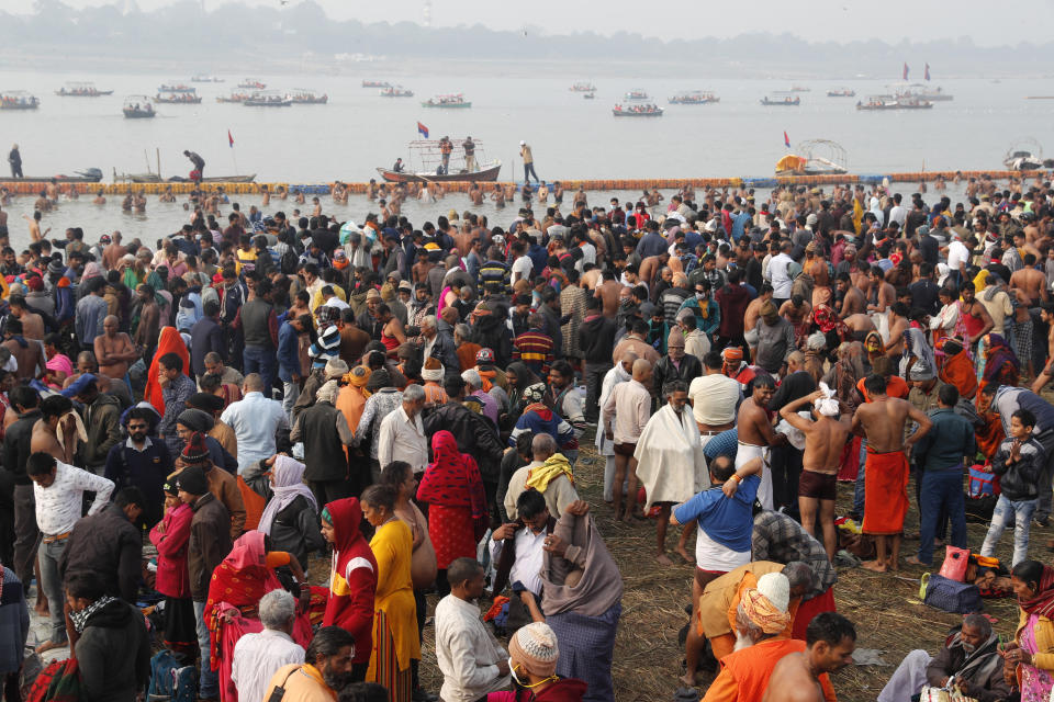 Hindu devotees crowd the Sangam, the confluence of three rivers — the Ganges, the Yamuna and the mythical Saraswati, to take a ritualistic bath during Makar Sankranti festival that falls during the annual traditional fair of Magh Mela festival, one of the most sacred pilgrimages in Hinduism, in Prayagraj, India. Friday, Jan. 14, 2022. Tens of thousands of devout Hindus, led by heads of monasteries and ash-smeared ascetics, took a holy dip into the frigid waters on Friday despite rising COVID-19 infections in the country. (AP Photo/Rajesh Kumar Singh)