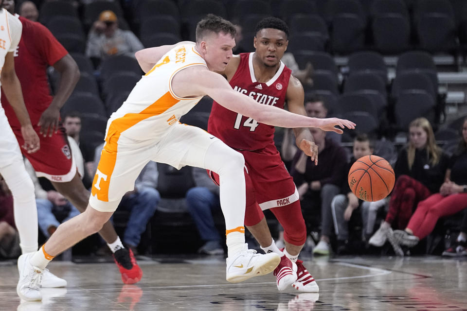 Tennessee guard Dalton Knecht (3) and North Carolina State guard Casey Morsell (14) chase the ball during the first half of an NCAA college basketball game in San Antonio, Saturday, Dec. 16, 2023. (AP Photo/Eric Gay)