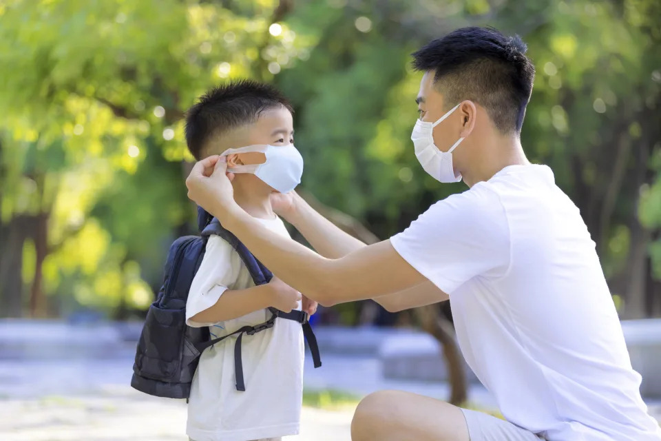 Father help his son wearing medical mask for protection Covid-19