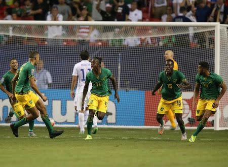 Jamaica forward Darren Mattocks (11) celebrates after scoring a goal with Je-Vaughn Watson (15) and Michael Hector (3) in the first half against the United States during the CONCACAF Gold Cup semifinal match at Georgia Dome. Mandatory Credit: Jason Getz-USA TODAY Sports