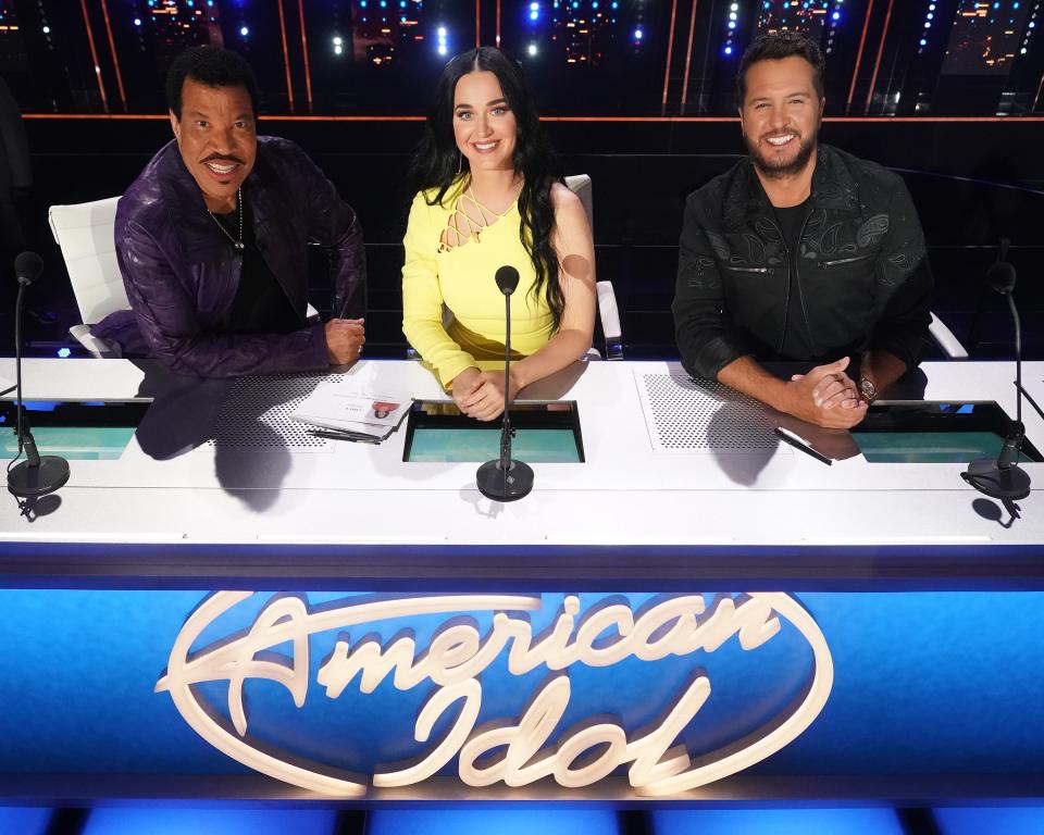 Lionel Richie in an all black outfit, Katy Perry in yellow dress, and Luke Bryan in an all black outfit at the judges table on "American Idol'