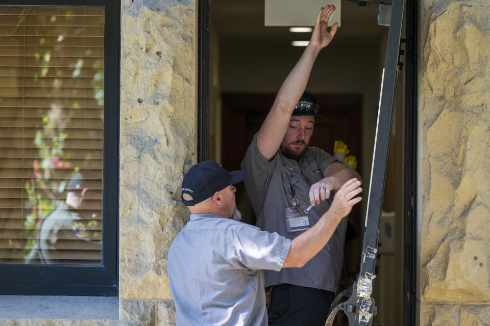 Campus maintenance workers repair a broken door at the office of the president at Stanford University in Palo Alto, Calif., Wednesday, June 5, 2024. Stanford University said people were arrested as law enforcement removed pro-Palestinian demonstrators who occupied a campus building early Wednesday that houses the university president and provost offices, with the school saying there was damage inside and outside the building. (AP Photo/Nic Coury)
