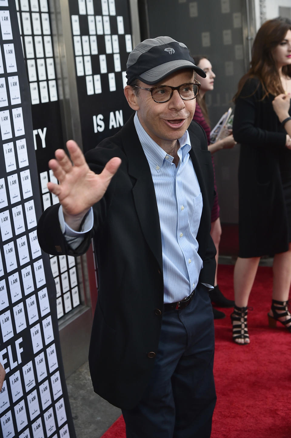 Rick wearing a cap and waving on the red carpet