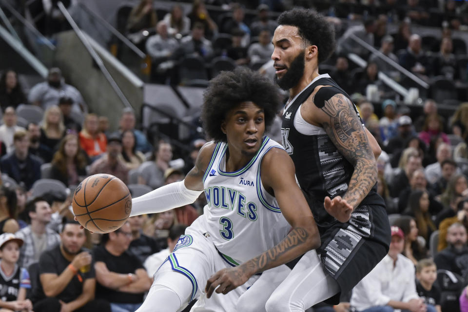 Minnesota Timberwolves' Jaden McDaniels (3) drives against San Antonio Spurs' Julian Champagnie during the first half of an NBA basketball game Saturday, Jan. 27, 2024, in San Antonio. (AP Photo/Darren Abate)