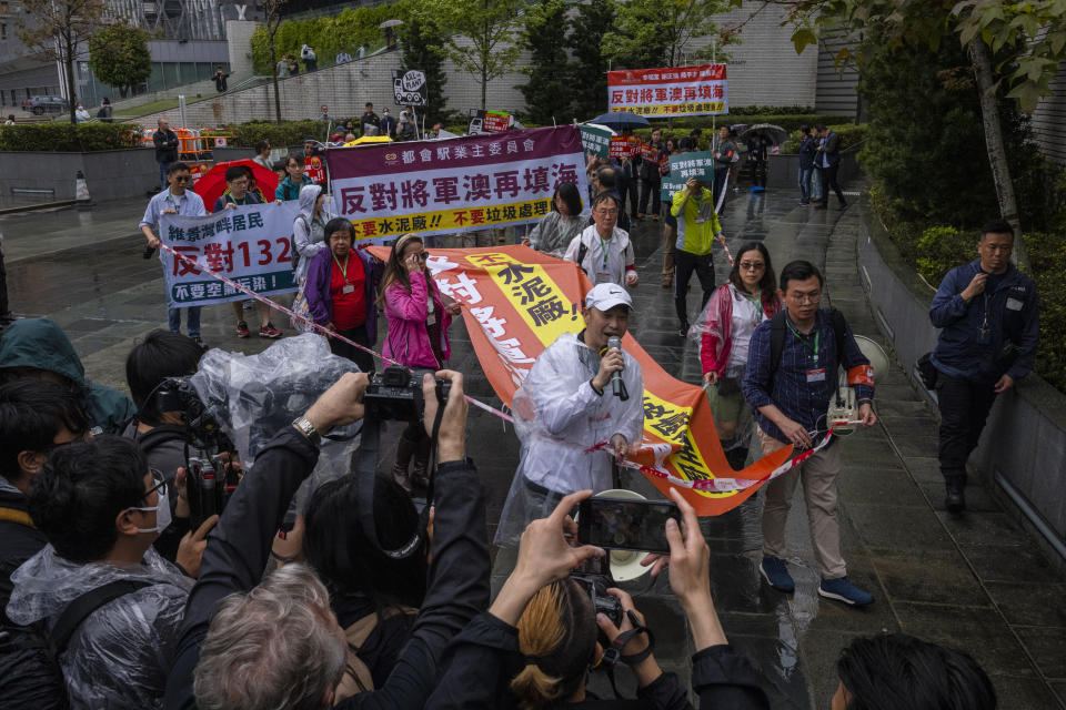 FILE - Protesters walk within a cordon line wearing number tags during a rally in Hong Kong, March 26, 2023. Living in Hong Kong today means juggling contradictory feelings. In 20 interviews, many said that when they focus on business indicators and everyday life, they see a recovery gathering pace after years of travel restrictions. But when it comes to anything political, the openness and freedoms that were once hallmarks of the Chinese-ruled former British colony seem permanently gone. (AP Photo/Louise Delmotte, File)