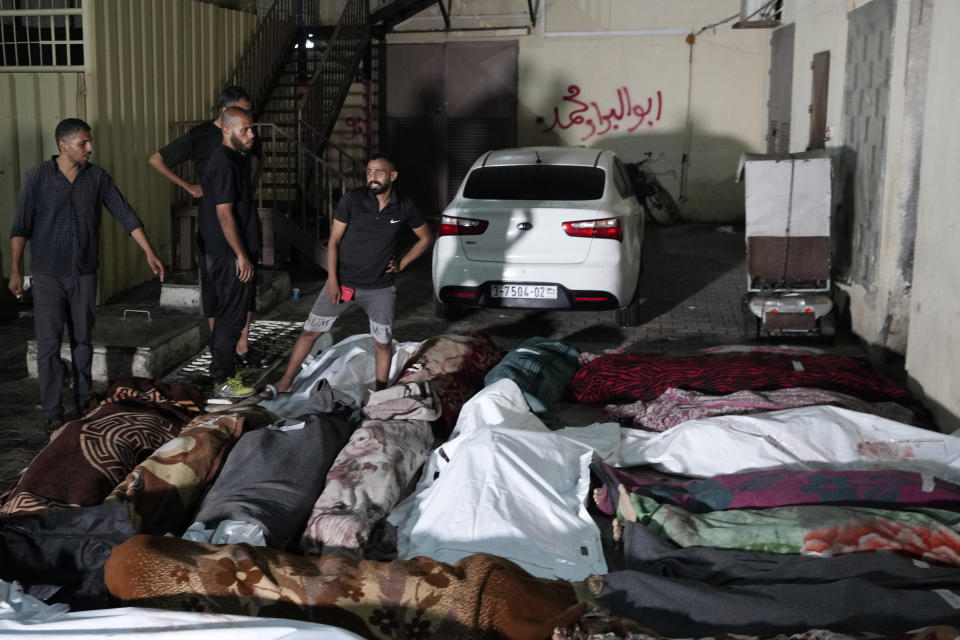 Palestinians mourn their relatives killed in an Israeli bombardment of UNRWA school at Nusseirat refugee camp, in front of the morgue of al-Aqsa Martyrs hospital in Deir al-Balah, central Gaza Strip, early Thursday, June 6, 2024. (AP Photo/Abdel Kareem Hana)