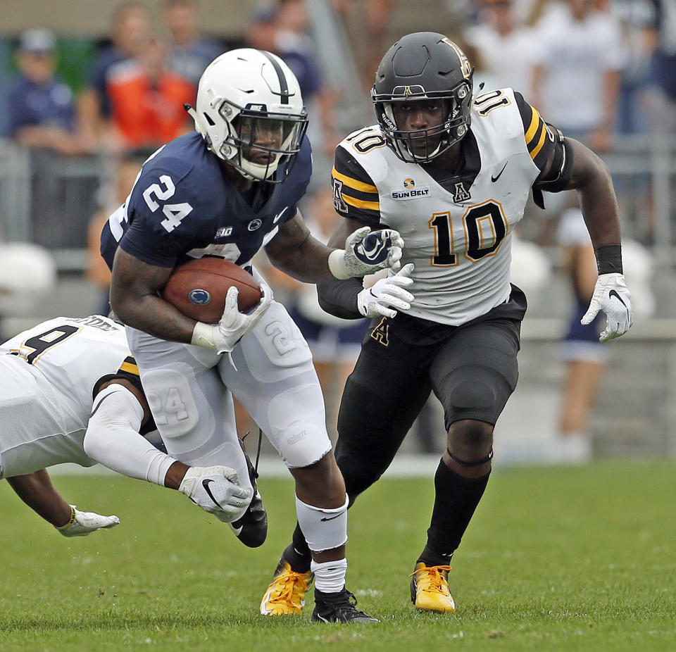 Penn State's Miles Sanders (24) evades a tackle by Appalachian State's Austin Exford (9) and Tim Frizzell (10) during the first half of an NCAA college football game in State College, Pa., Saturday, Sept. 1, 2018. (AP Photo/Chris Knight)