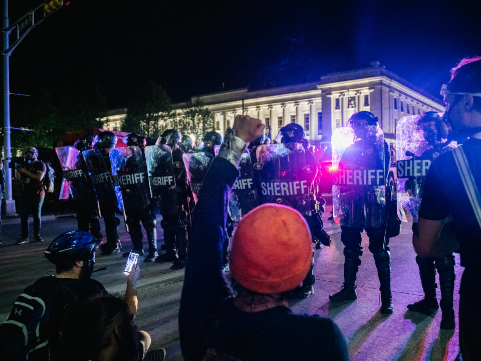 Demonstrators sit in the street, in front of law enforcement, on August 25, 2020 in Kenosha, Wisconsin. (Brandon Bell/Getty Images)