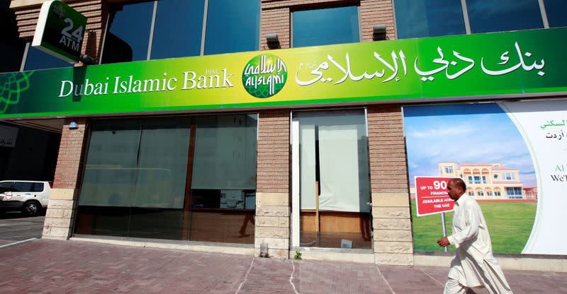 FILE PHOTO: A man walks past a branch of Dubai Islamic Bank branch along Khalid Bin Al-Waleed Road in Dubai
