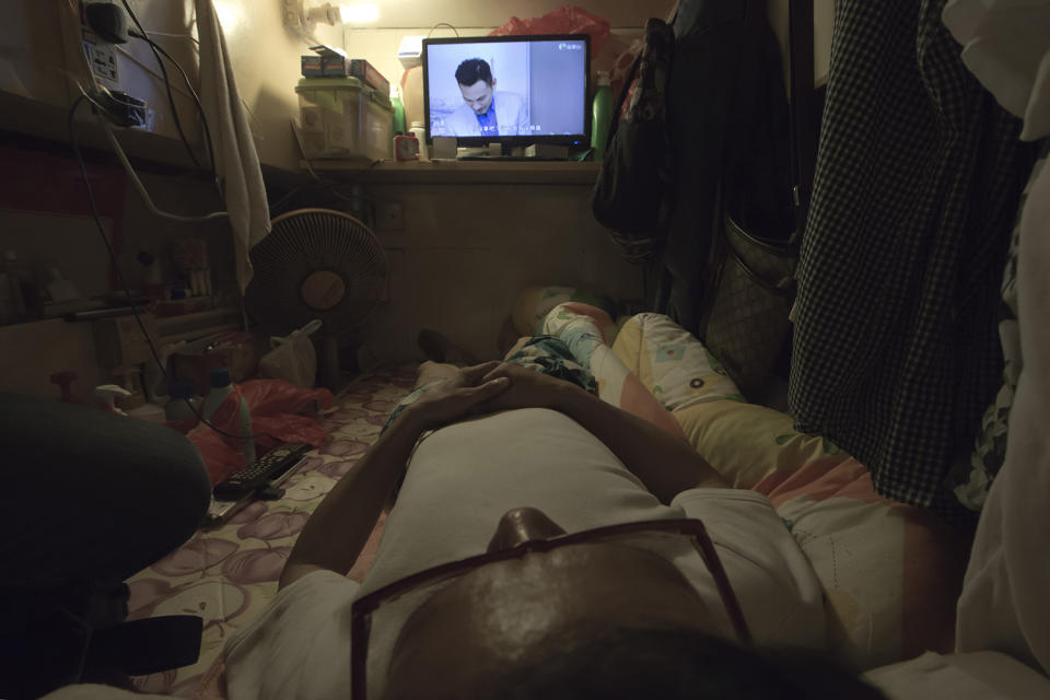 <p>Simon Wong, an unemployed man, watches TV in his “coffin home” in Hong Kong, April 25, 2017. (Photo: Kin Cheung/AP) </p>