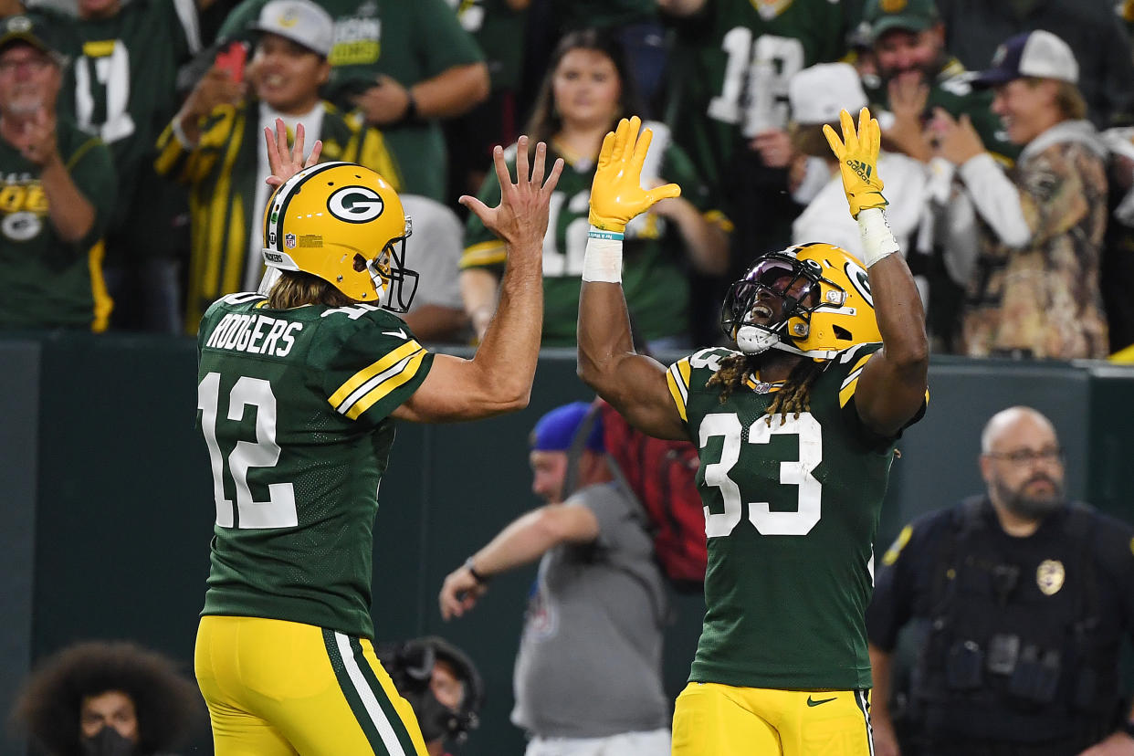 GREEN BAY, WISCONSIN - SEPTEMBER 20: Aaron Jones #33 of the Green Bay Packers celebrates a touchdown against the Detroit Lions with teammate Aaron Rodgers #12 during the first half at Lambeau Field on September 20, 2021 in Green Bay, Wisconsin. (Photo by Quinn Harris/Getty Images)