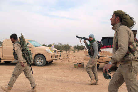 Syrian Democratic Forces (SDF) fighters walk with their weapons during an offensive against Islamic State militants in northern Raqqa province, Syria February 8, 2017. REUTERS/Rodi Said