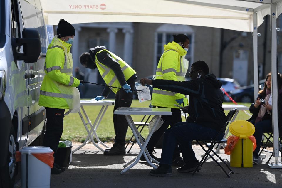 People take Covid-19 tests at a mobile novel coronavirus surge testing centre in Brockwell Park in south London, on April 13, 2021. - Britain said late Monday it had hit a target to offer a coronavirus vaccine first dose to all over-50s by mid-April, as England's lockdown-weary population toasted a significant easing of restrictions with early morning pints and much-needed haircuts. (Photo by DANIEL LEAL-OLIVAS / AFP) (Photo by DANIEL LEAL-OLIVAS/AFP via Getty Images)