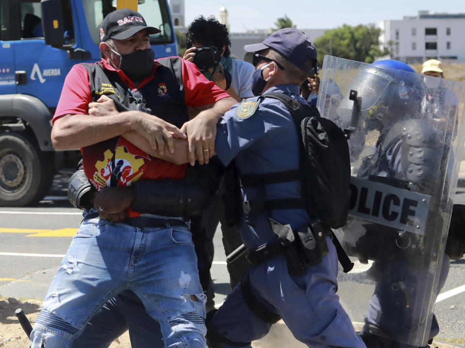 Protesters clash with police at the start of a planned march to Parliament in Cape Town, South Africa, as police stop all protests before they reach parliament Wednesday, Feb. 24, 2021. Various groups planned to protest during Finance Minister Tito Mboweni's 2021 Budget Speech. (AP Photo/Nardus Engelbrecht)