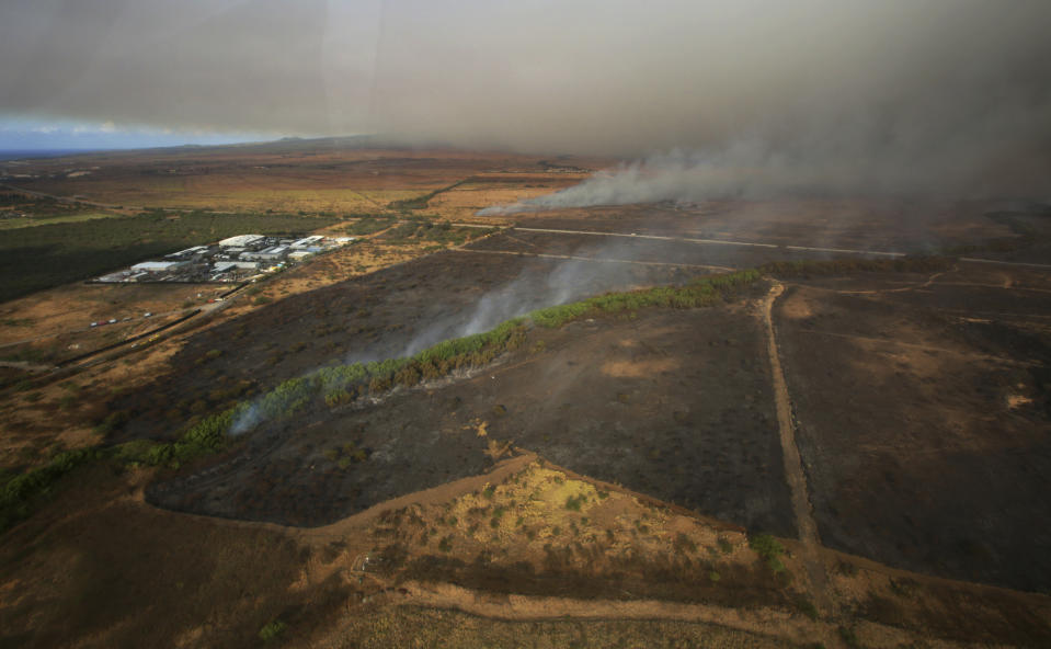 This Thursday, July 11, 2019 photo provided by the County of Maui shows a brush fire that has prompted evacuation orders and diverted flights on the island of Maui in Hawaii. Maui Fire Department officials said hot, dry and windy conditions Friday, July 12, 2019, could worsen the fire. The National Guard is helping firefighters and conducting water drops with a helicopter. The blaze fueled by dry brush and strong winds erupted Thursday on northwestern side of the island, burning 14 square miles (36 square kilometers) of fields. (Chris Sugidono/County of Maui via AP)