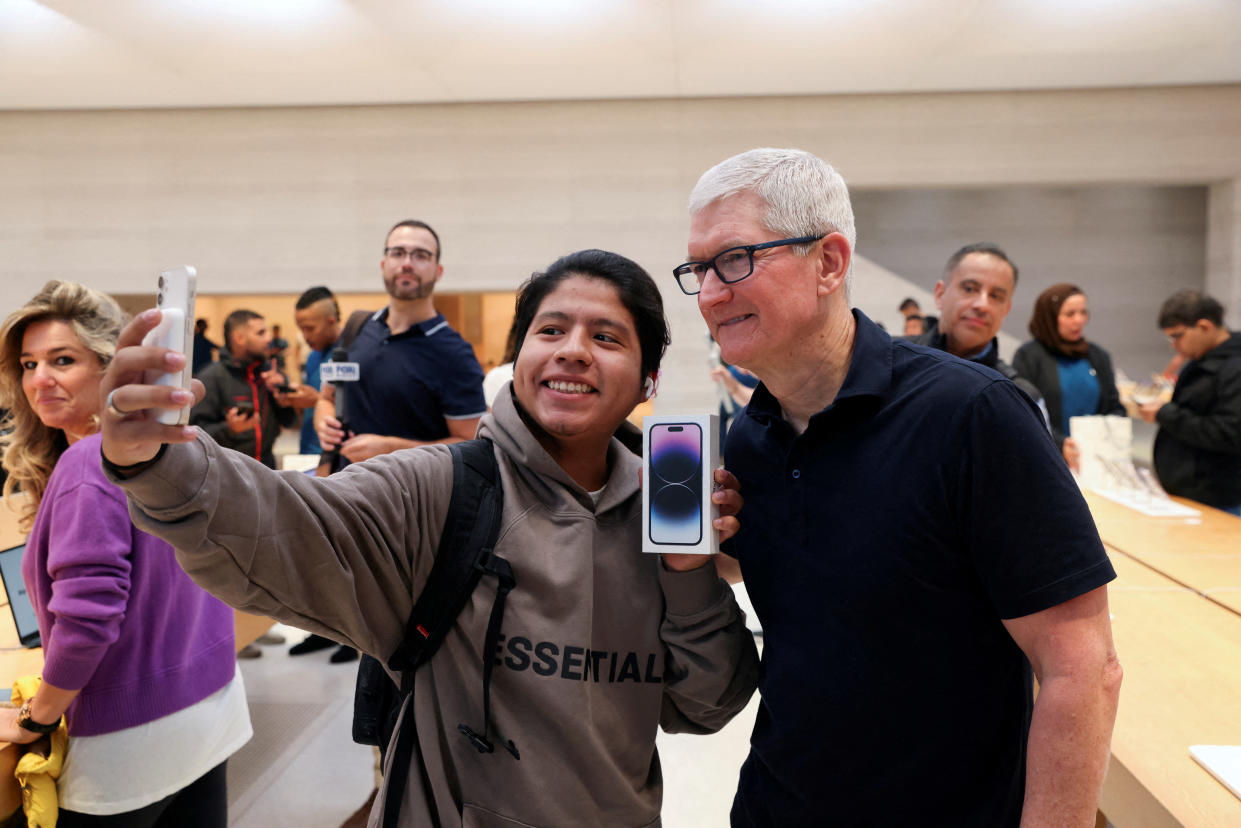 A customer takes a selfie with Apple CEO Tim Cook and an iPhone 14 Pro, at the Apple Fifth Avenue store, as Apple Inc's new iPhone 14 models go on sale, in Manhattan, New York City U.S. September 16, 2022. REUTERS/Andrew Kelly REFILE - CORRECTING INFORMATION