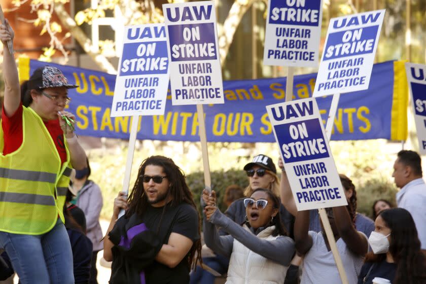 LOS ANGELES, CA - NOVEMBER 16, 2022 - - Menelik Tafari, second from left, who holds a PhD from UCLA and is a research fellow at the university, joins fellow academic workers who walk the picket line at Portola Plaza on the UCLA campus in Los Angeles on November 16, 2022. Tafari is one of the organizers of the strike across all UC California campuses for better wages and benefits. His doctoral research at UCLA focuses on school design and iteration; and the integration of encounter groups, culture circles and design teams. 48,000 University of California academic workers - including postdoctoral scholars, graduate teaching assistants and researchers - walked off the job this week in a strike billed as the largest at any academic institution in history. (Genaro Molina / Los Angeles Times)